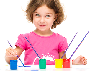 Image showing Little girl is painting with gouache