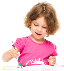 Image showing Little girl is painting with gouache