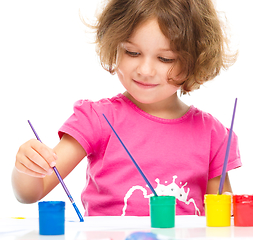 Image showing Little girl is painting with gouache