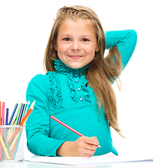 Image showing Little girl is drawing using pencils