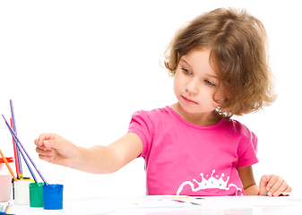 Image showing Little girl is painting with gouache