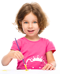 Image showing Little girl is painting with gouache