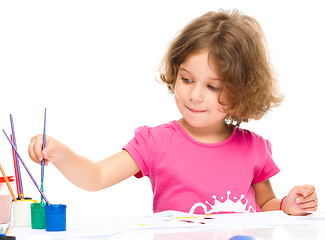 Image showing Little girl is painting with gouache