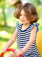 Image showing Young happy girl is swinging in playground