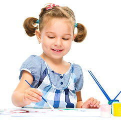 Image showing Little girl is painting with gouache