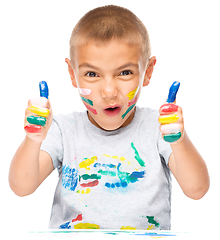 Image showing Portrait of a cute boy playing with paints