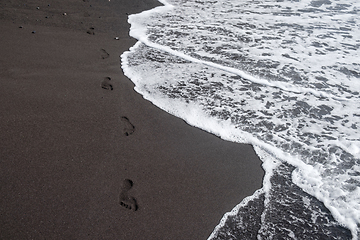 Image showing foot prints on black sand