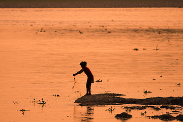 Image showing Asian Woman fishing in the river, silhouette at sunset