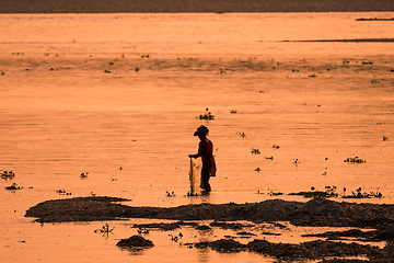 Image showing Asian Woman fishing in the river, silhouette at sunset