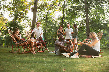 Image showing Happy friends eating and drinking beers at barbecue dinner on sunset time