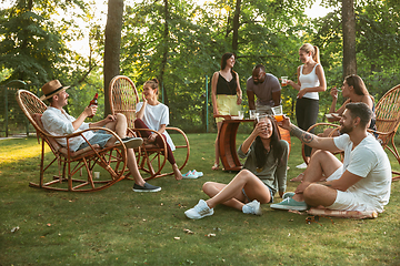 Image showing Happy friends eating and drinking beers at barbecue dinner on sunset time