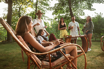 Image showing Happy friends eating and drinking beers at barbecue dinner on sunset time