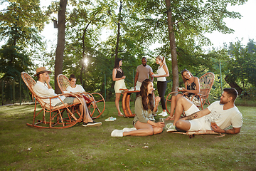 Image showing Happy friends eating and drinking beers at barbecue dinner on sunset time