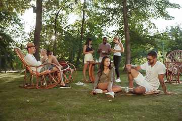 Image showing Happy friends eating and drinking beers at barbecue dinner on sunset time