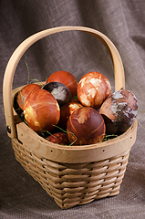 Image showing Speckled eggs in basket on brown background.