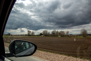 Image showing View of plowed field from the window of the car.