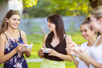 Image showing Happy friends eating at barbecue dinner on sunset time