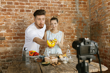 Image showing Young couple cooking and recording live video for vlog and social media