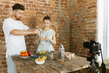 Image showing Young couple cooking and recording live video for vlog and social media