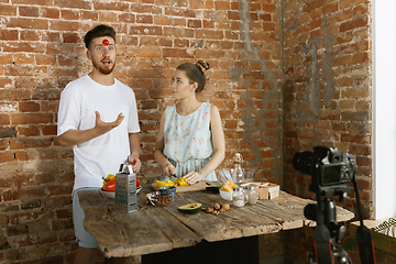 Image showing Young couple cooking and recording live video for vlog and social media