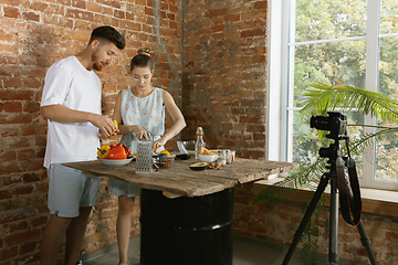 Image showing Young couple cooking and recording live video for vlog and social media