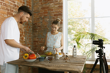 Image showing Young couple cooking and recording live video for vlog and social media