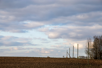 Image showing Landscape with plowed field, trees and blue sky