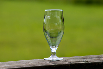 Image showing Empty glass of beer on green nature background.