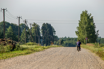 Image showing Landscape with rural road and man on moped..