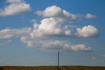Image showing Landscape with field and cloudy blue sky.