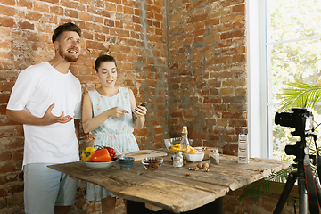 Image showing Young couple cooking and recording live video for vlog and social media