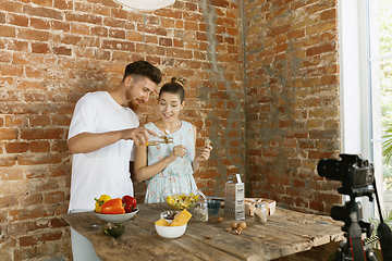 Image showing Young couple cooking and recording live video for vlog and social media