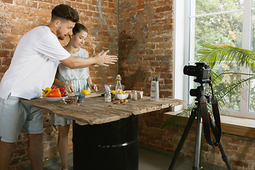 Image showing Young couple cooking and recording live video for vlog and social media