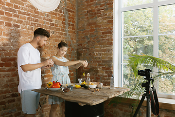 Image showing Young couple cooking and recording live video for vlog and social media