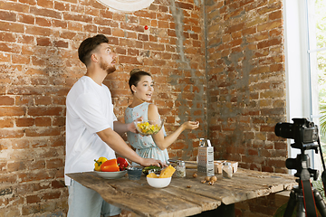 Image showing Young couple cooking and recording live video for vlog and social media