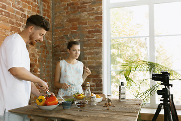 Image showing Young couple cooking and recording live video for vlog and social media