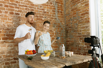 Image showing Young couple cooking and recording live video for vlog and social media