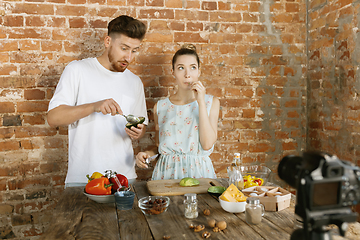 Image showing Young couple cooking and recording live video for vlog and social media