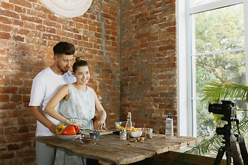 Image showing Young couple cooking and recording live video for vlog and social media