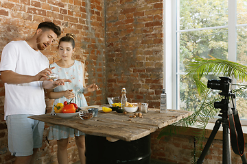 Image showing Young couple cooking and recording live video for vlog and social media