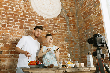 Image showing Young couple cooking and recording live video for vlog and social media