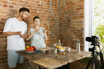 Image showing Young couple cooking and recording live video for vlog and social media