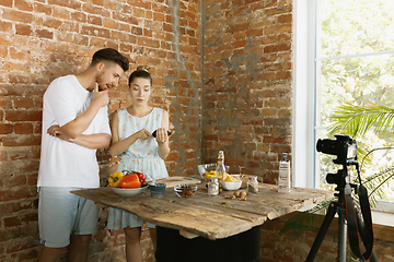 Image showing Young couple cooking and recording live video for vlog and social media