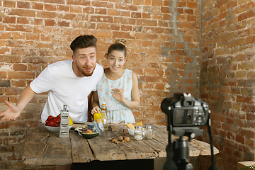 Image showing Young couple cooking and recording live video for vlog and social media