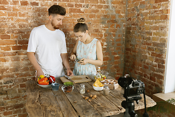 Image showing Young couple cooking and recording live video for vlog and social media