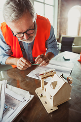 Image showing Close up of male architect-engineer making a model of house