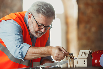 Image showing Close up of male architect-engineer making a model of house