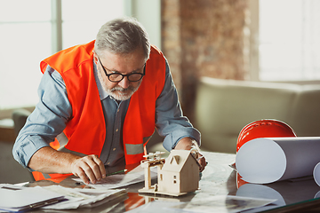 Image showing Close up of male architect-engineer making a model of house