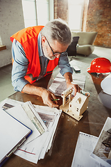 Image showing Close up of male architect-engineer making a model of house