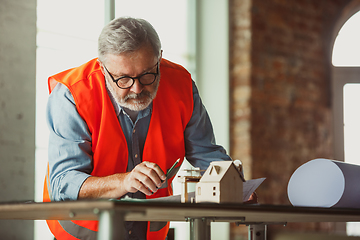 Image showing Close up of male architect-engineer making a model of house